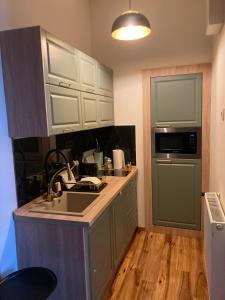 a kitchen with white cabinets and a sink and a counter at LILI Deluxe Apartman in Tapolca
