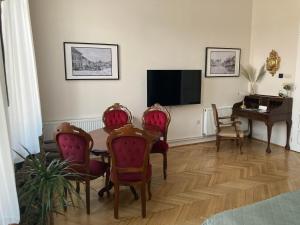 a living room with a table and chairs and a television at LILI Deluxe Apartman in Tapolca