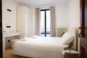 a white bedroom with a large bed and a window at Sunshine HOTEL in Mestre