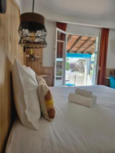 a bed with two towels and two pillows on it at L'auberge Camarguaise in Saintes-Maries-de-la-Mer