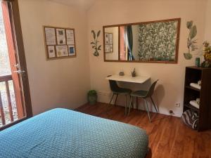 a bedroom with a bed and a mirror and a table at Chambre Boscodon in Savines