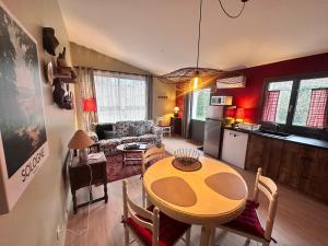 a living room with a dining room table and a kitchen at L'annexe du vigneron in Châtillon-sur-Cher