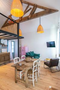 a living room with a wooden table and chairs at Welcôm Apparts-chic et intimiste-100m du Port in La Teste-de-Buch