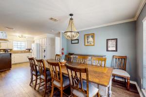 a kitchen and dining room with a wooden table and chairs at Poolside Bliss! Christian Pass Family Home w/ Yard in Long Beach