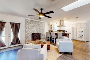 a living room with white chairs and a ceiling fan at Poolside Bliss! Christian Pass Family Home w/ Yard in Long Beach
