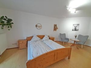 a bedroom with a wooden bed and a table and chairs at Bauernhof Landsamer in Aschau im Chiemgau