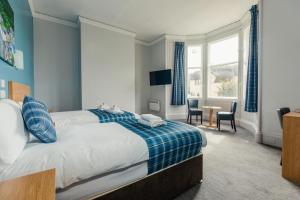 a bedroom with a bed and a table and chairs at The Caledonian Thistle Hotel in Callander