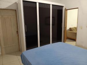 a bedroom with a blue bed and sliding glass doors at Recanto Família lima e Silva in Garanhuns