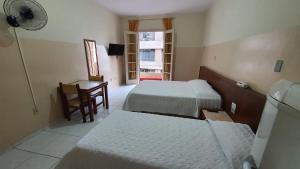 a bedroom with two beds and a desk and a window at Hotel Plaza Olido in São Paulo +53 photos