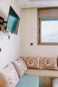 a couch with pillows and a flat screen tv at Shaka Ashore Imsouane in Imsouane