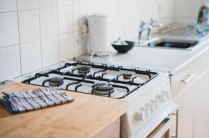 a stove top oven in a kitchen next to a sink at Causeyside apartment in Paisley +5 photos