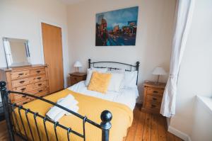a bedroom with a bed and a painting on the wall at Causeyside apartment in Paisley