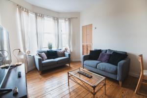 a living room with two couches and a coffee table at Causeyside apartment in Paisley
