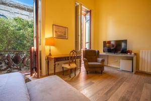a room with a bed and a desk and a television at Al Bastione di Cagliari in Cagliari