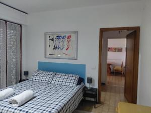 a bedroom with a bed with a blue and white checked bedspread at appartamento Modì in Pistoia