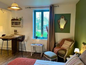 a room with a bed and a table and a window at La mésAnges in Giverny