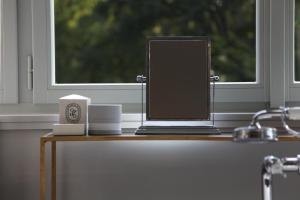 a laptop sitting on a table next to a window at Villa Čisovice - Functionalist Retreat near Prague in Čisovice +8 photos