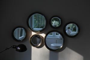 a group of mirrors on a wall with a lamp at Villa Čisovice - Functionalist Retreat near Prague in Čisovice