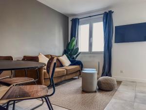a living room with a couch and a table at Le Croizat - Neyrpic in Saint-Martin-dʼHères