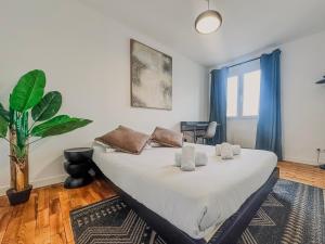 a bedroom with a large white bed with a plant at Le Croizat - Neyrpic in Saint-Martin-dʼHères