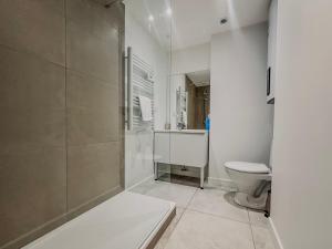 a white bathroom with a shower and a toilet at Le Croizat - Neyrpic in Saint-Martin-dʼHères