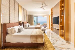 a hotel room with two beds and a television at Garza Blanca Sanctuary Puerto Vallarta in Puerto Vallarta