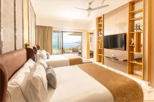a hotel room with two beds and a television at Garza Blanca Sanctuary Puerto Vallarta in Puerto Vallarta