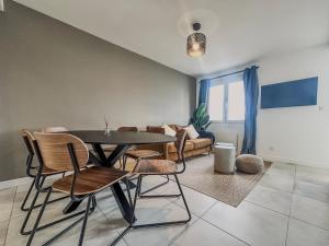 a dining room with a table and chairs and a couch at Le Croizat - Neyrpic in Saint-Martin-dʼHères