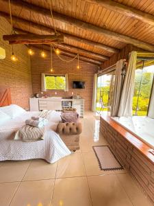 a bedroom with two beds and a bath tub at Chalés Aconchego dos Canyons in Praia Grande