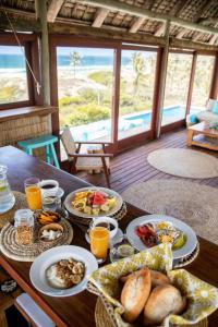 a table with plates of food and drinks on it at Travessia Beach Lodge in Inhambane