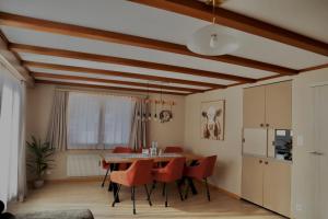 a dining room with a table and red chairs at Chalet Aloa in Adelboden