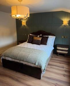 a bedroom with a large bed with green walls at The Huntsman in Norwich