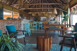 a restaurant with tables and chairs in a room at Travessia Beach Lodge in Inhambane