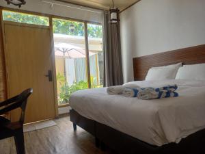 a bedroom with a bed with towels on it at Dhigurah Holidays in Dhigurah