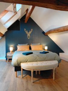 a bedroom with a large bed with a bench in it at Gites au fil des châteaux de la Loire in Saint-Georges-sur-Cher +73 photos