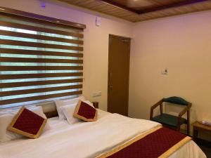 a bedroom with a white bed and a window at Road Trip Retreat in Belagula
