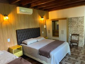 a bedroom with a large bed and a chair at Casa nas Montanhas em Domingos Martins in Domingos Martins +137 photos