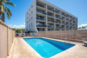 a swimming pool in front of a apartment building at Island Surf 304 - Renovated, Ocean Views, Split AC in Kihei