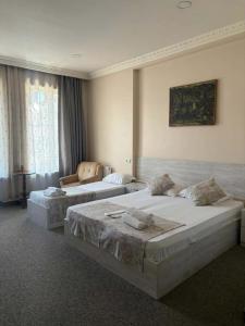 ein Schlafzimmer mit zwei Betten und einem Stuhl in der Unterkunft Platformatbilisi in Tbilisi City