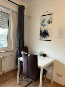 a desk and chairs in a room with a window at Studio à Niederkorn in Differdange