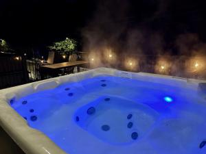 a jacuzzi bathtub with blue lighting in a backyard at night at The First Tracks Flat in Revelstoke