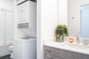 a white bathroom with a sink and a toilet at The First Tracks Flat in Revelstoke +7 photos