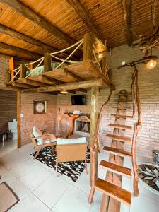 a living room with a spiral staircase in a house at Chalés Aconchego dos Canyons in Praia Grande