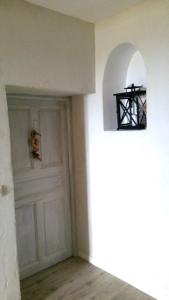 a room with a white door with a dog in it at Hôtel Le Niobel in Belgodère
