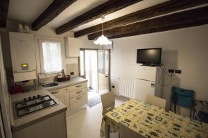 a kitchen with a table and a stove top oven at Dimora Marchiada -apeliving- Pellestrina Ve in Pellestrina