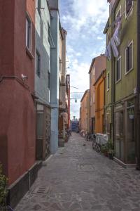 an alley with colorful buildings on a city street at Dimora Marchiada -apeliving- Pellestrina Ve in Pellestrina