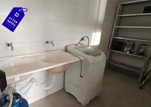 a bathroom with a sink and a trash can at Casa Coqueiro 02 in Primavera do Leste +11 photos