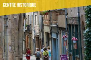 a group of people walking down a narrow street at La Nef - Climatisation, Parking & Wifi à 150m de la Cathédrale in Rodez +3 photos