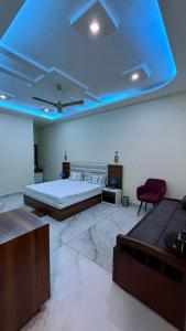 a bedroom with a bed and a blue ceiling at Hotel Amrindra in Kharar +7 photos