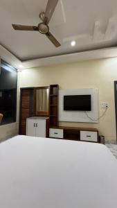 a bedroom with a bed and a flat screen tv at Hotel Amrindra in Kharar